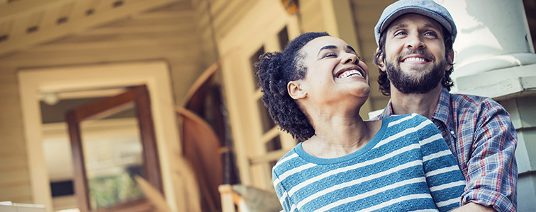 young couple sitting on home porch and laughing